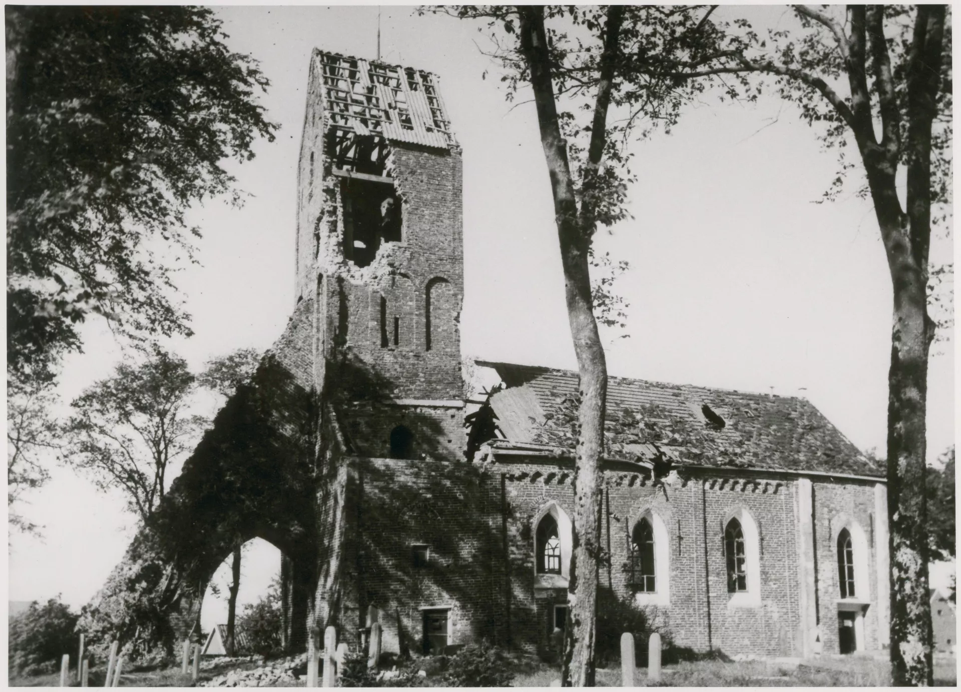Een zwaar beschadigde kerk met gaten in het dak en de toren.