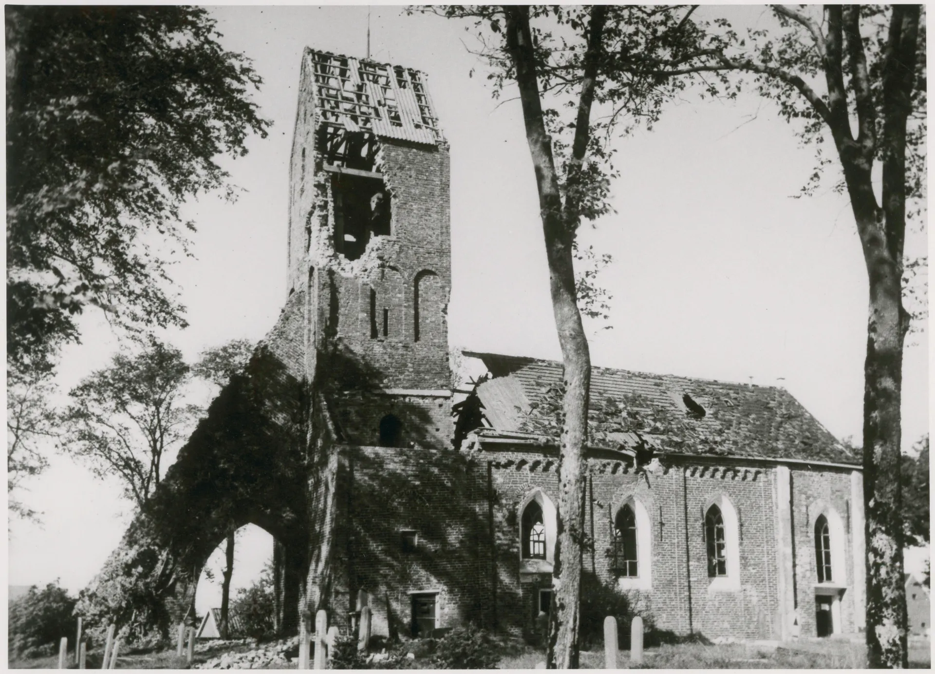 Een zwaar beschadigde kerk met gaten in het dak en de toren.