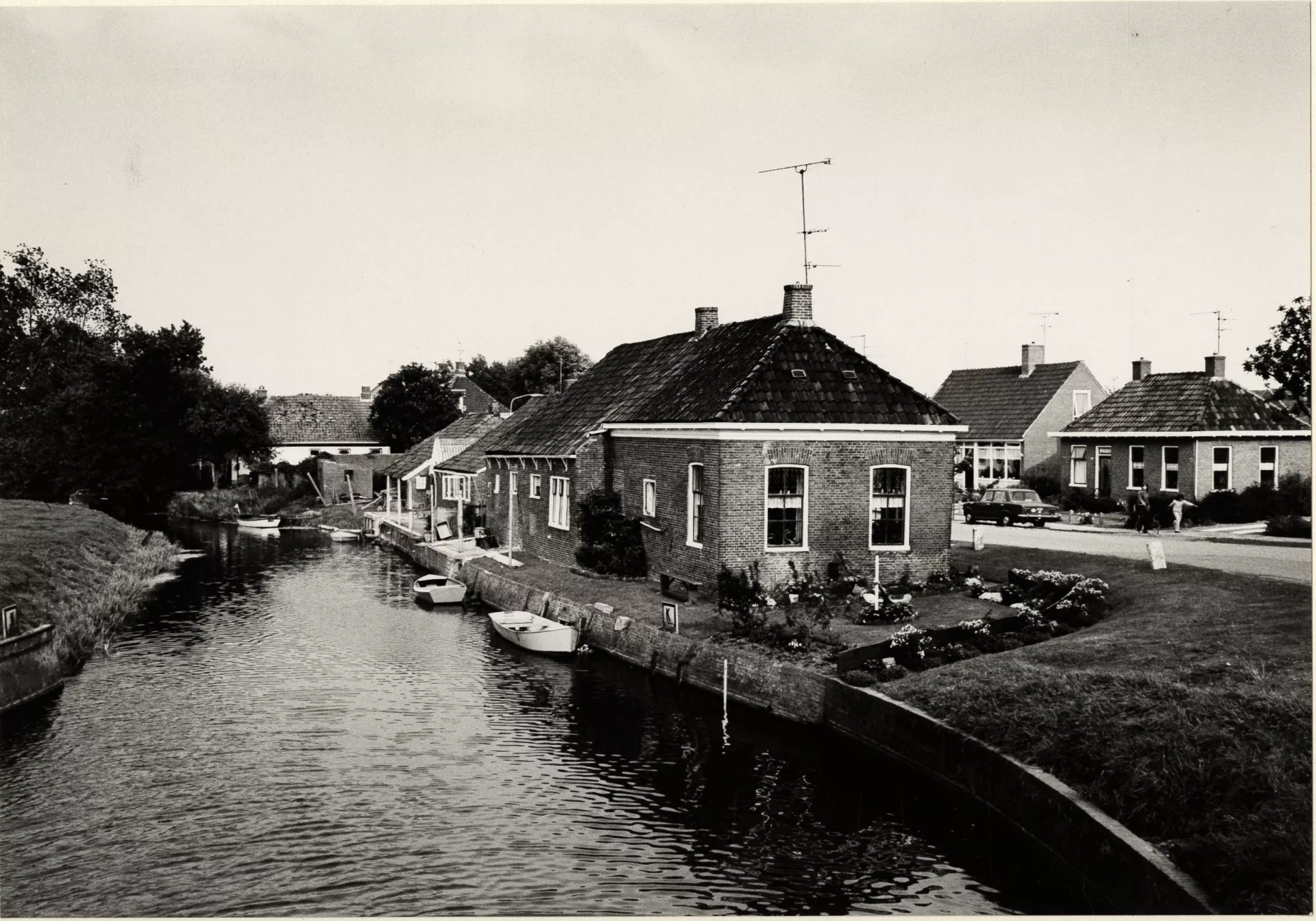 Pand aan een riviertje dat dienst deed als noodhospitaal tijdens de oorlog met andere huizen in de achtergrond.