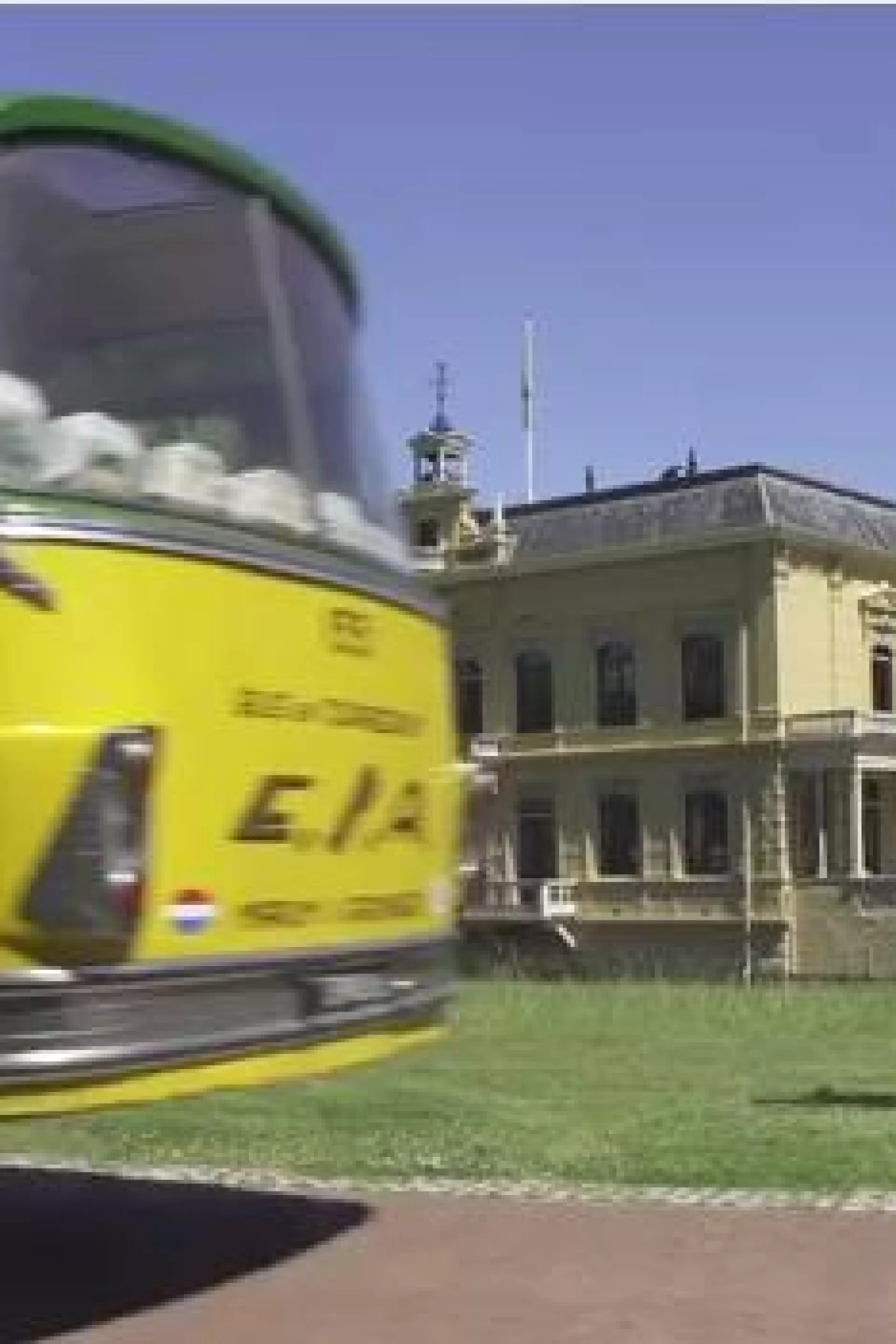 Een gele bus rijdt langs Borg Nienoord: een statig, historisch gebouw.