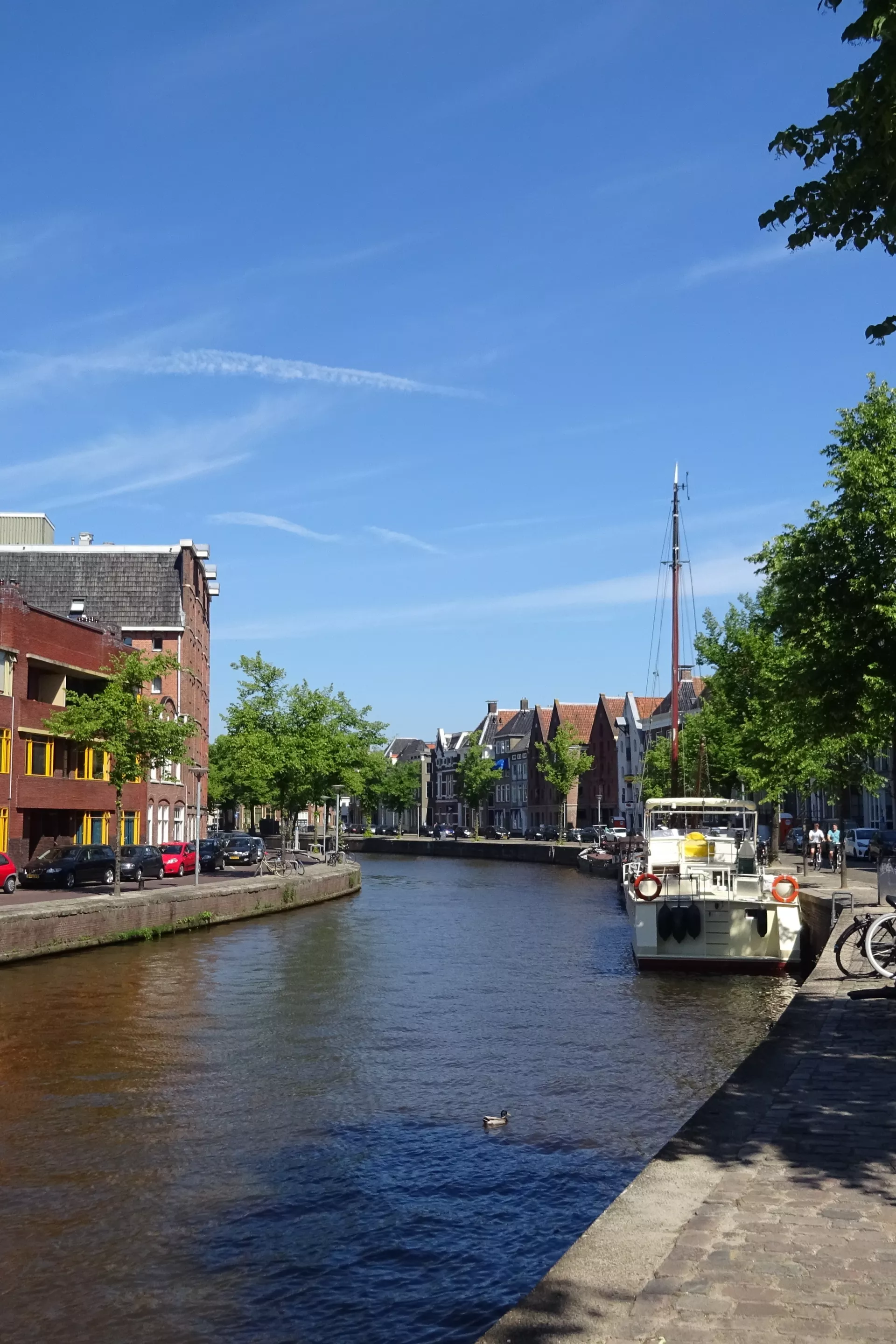 Een zonnige dag aan een diep in Groningen met fietsen langs de kade.