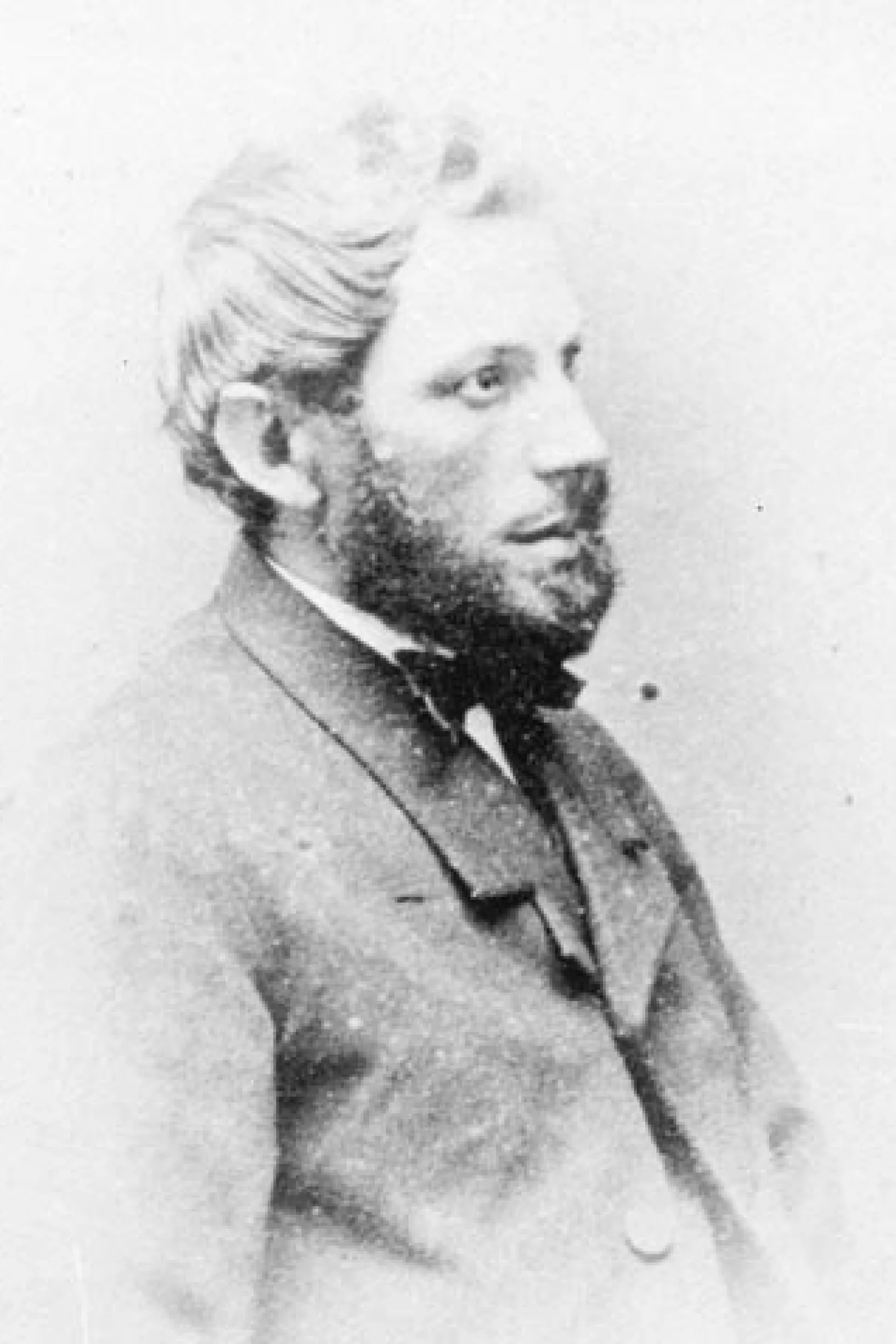 Oud portret van een man met baard en vlinderdas in profiel.